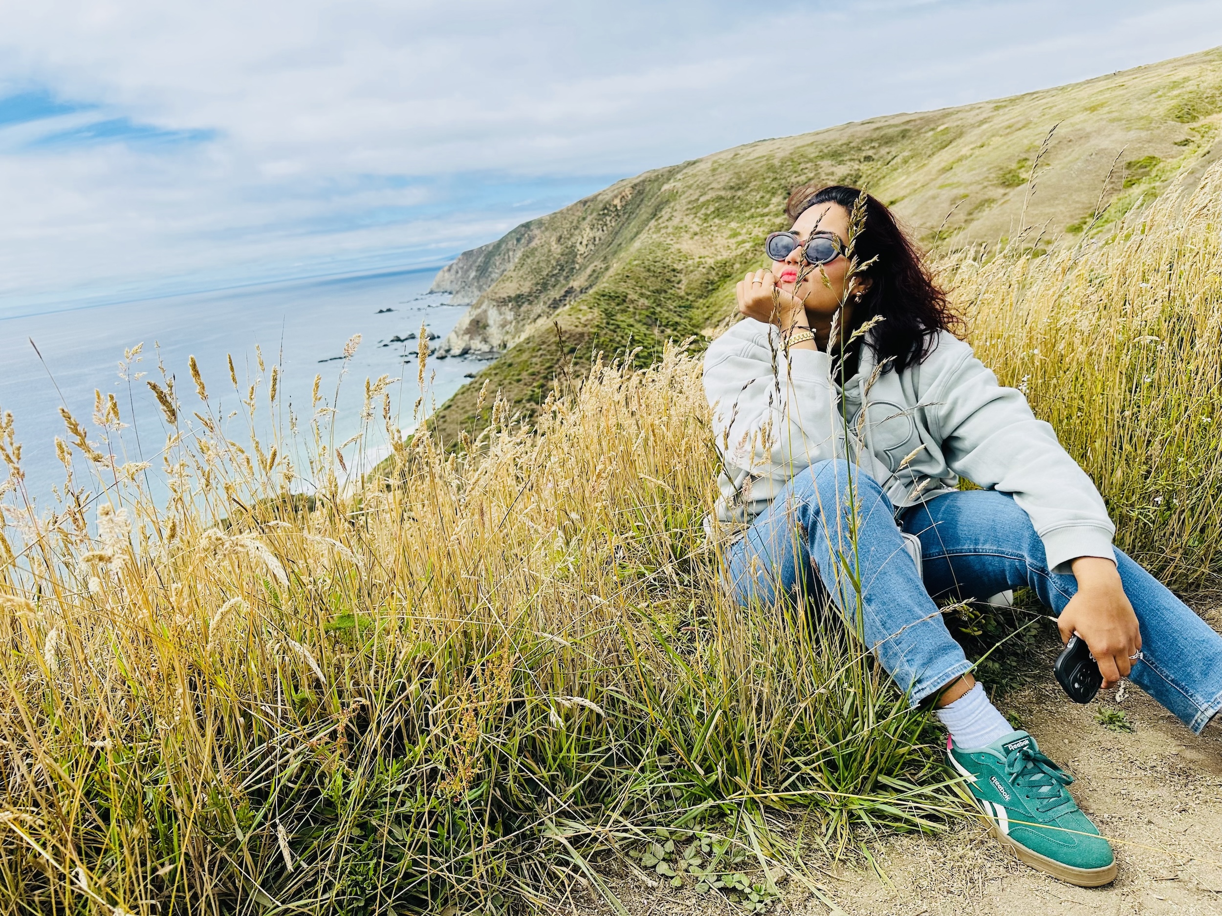 Vrushali Date seated on a coastal hillside, California